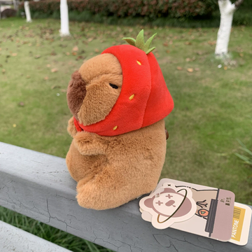 Peluche de capibara con gorrito de fresa